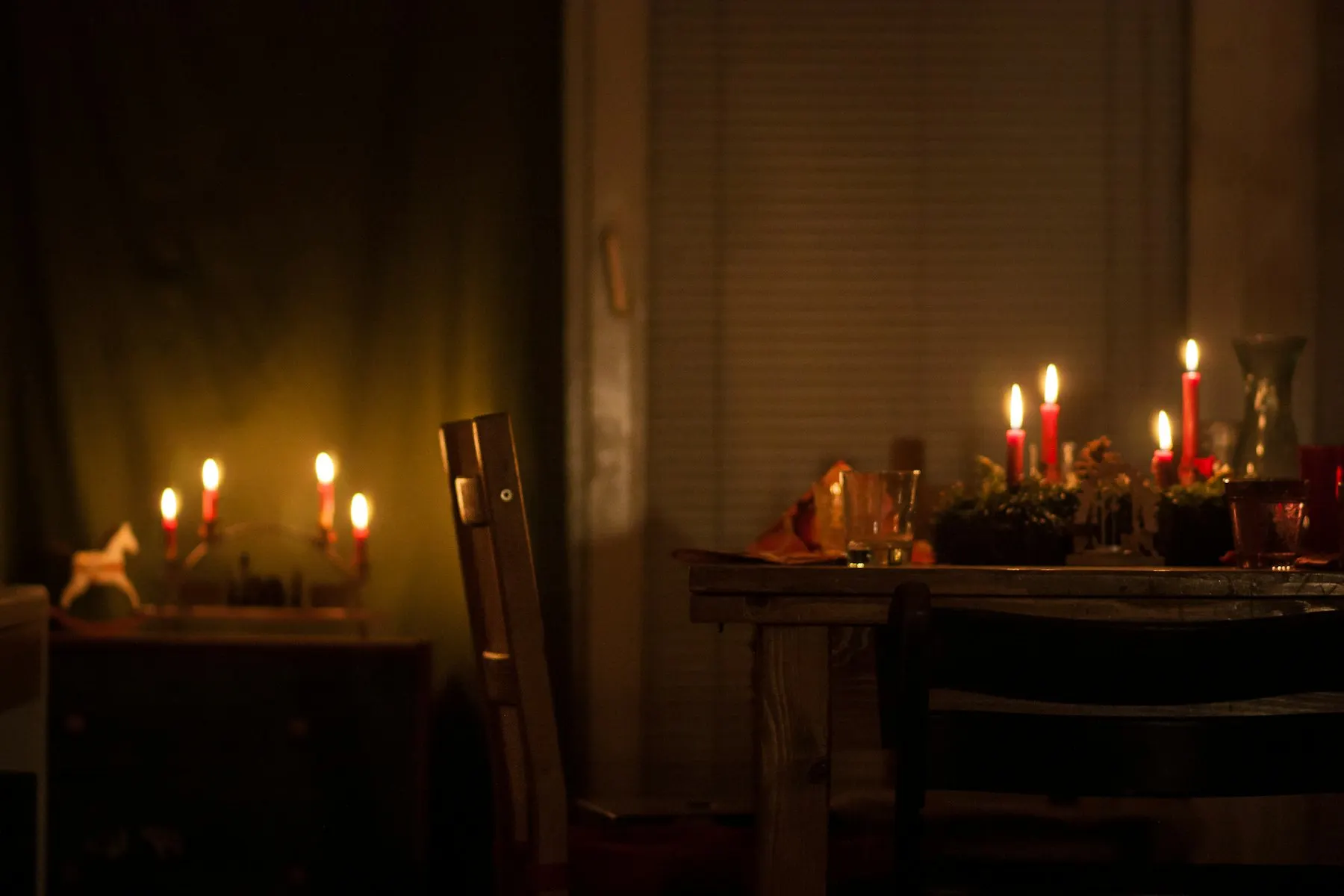 Lit candles on a wooden dinner table