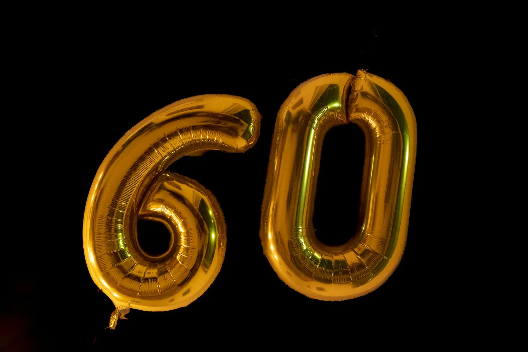 Gold number balloons on a black backdrop