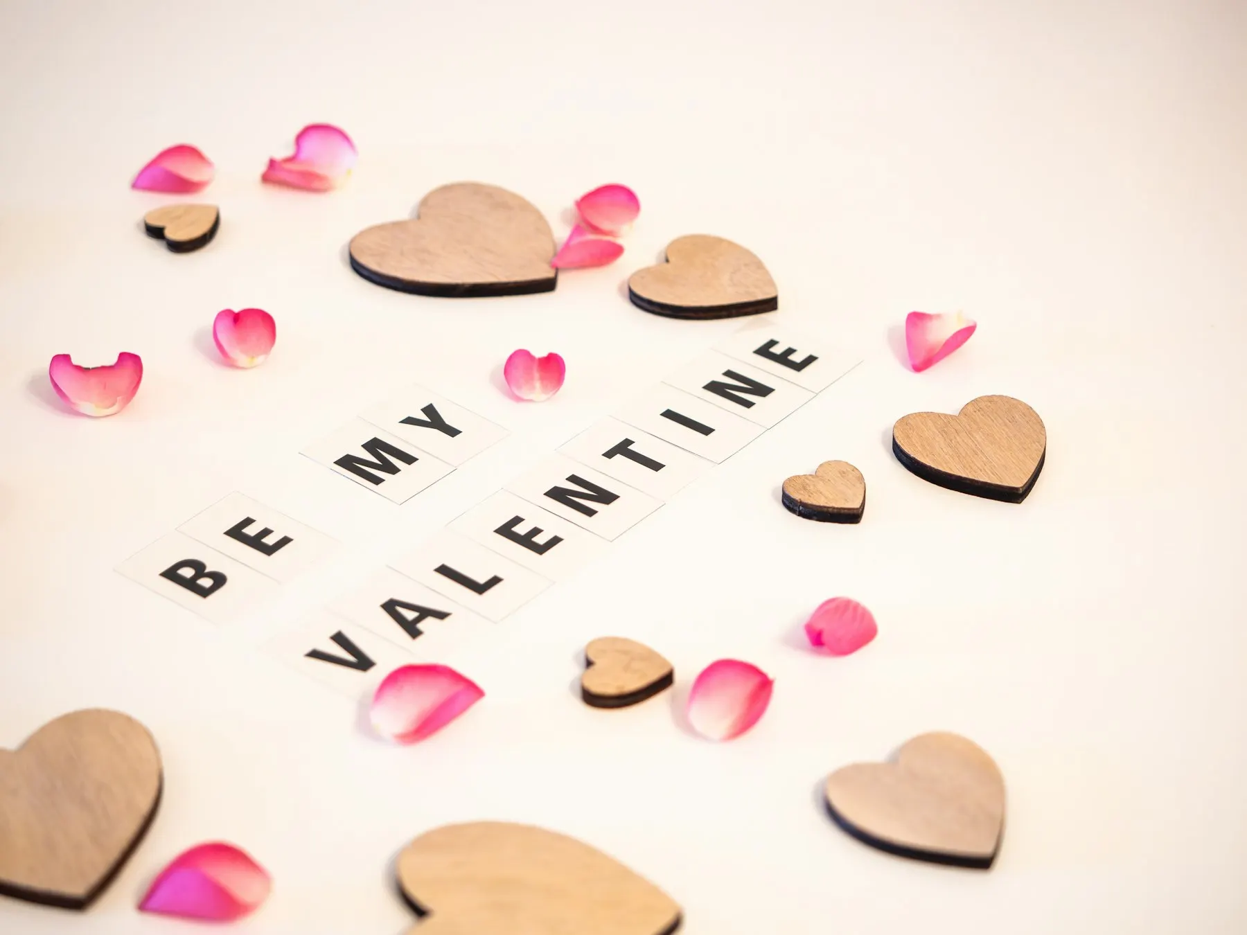 Candles, wooden hearts and rose petals